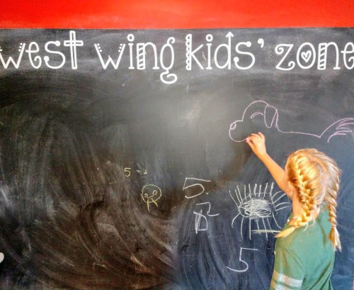 girl drawing on chalkboard family friendly restaurant