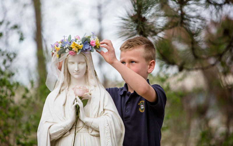 Catholic Schools of Greater Kalamazoo: boy placing crown on statue
