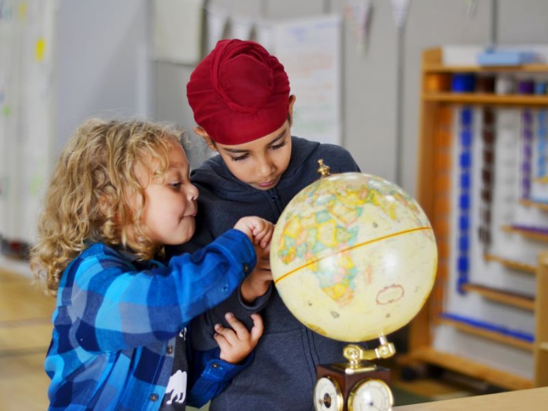 Battle Creek Montessori Academy kids using globe