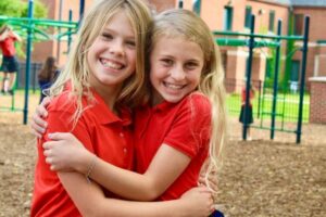 catholic schools of greater kalamazoo: friends hugging at recess