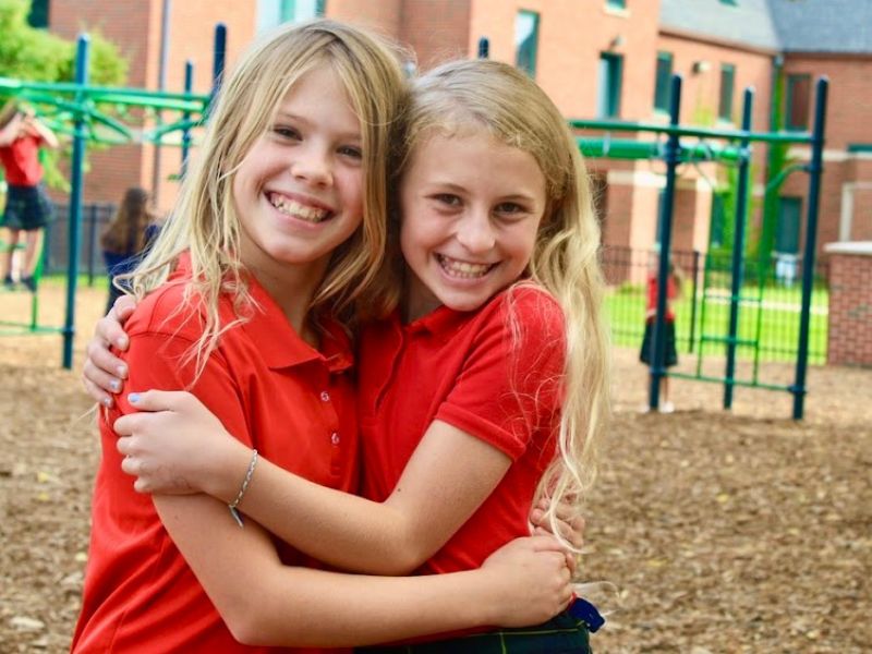 catholic schools of greater kalamazoo: friends hugging at recess