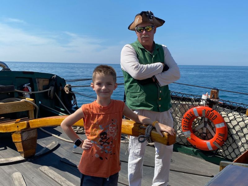 boy posing with pirate ship captain